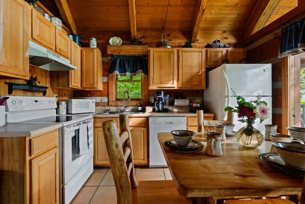 Kitchen and dining area with rustic table at Nestled Oaks cabin