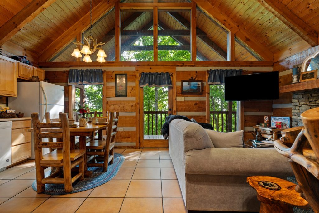 Living and dining area with open windows at Nestled Oaks cabin