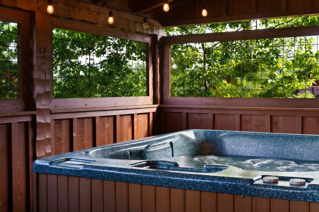 Hot tub on covered porch at Dancing Embers cabin