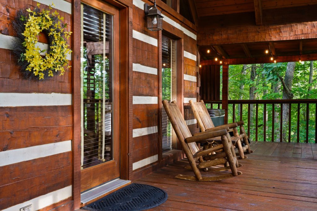 Porch rocking chairs with flag at Nestled Oaks cabin