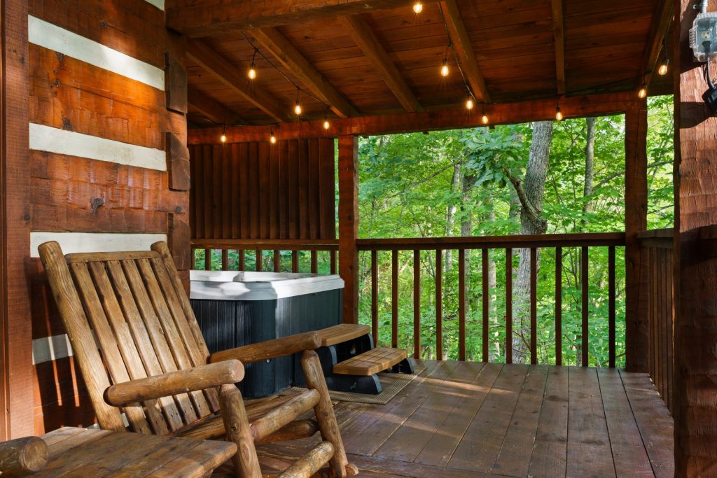 Porch rocking chairs and hot tub at Nestled Oaks cabin